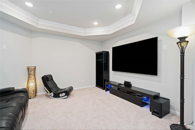 cinema room with a raised ceiling, ornamental molding, and light carpet