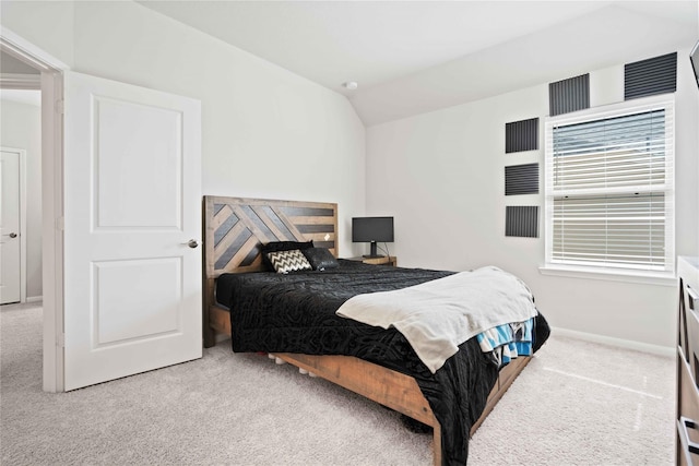 carpeted bedroom with lofted ceiling