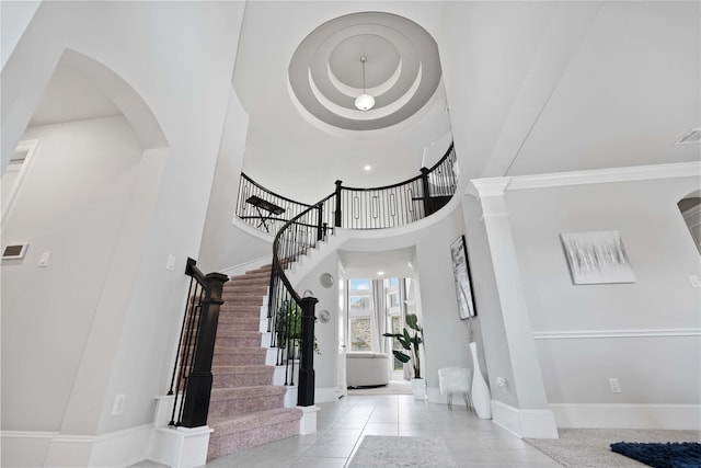 entrance foyer featuring a towering ceiling and light tile patterned floors