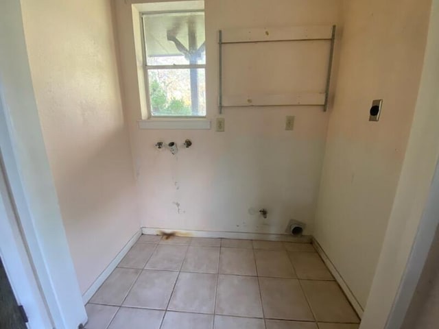 clothes washing area featuring electric dryer hookup, light tile patterned floors, and washer hookup