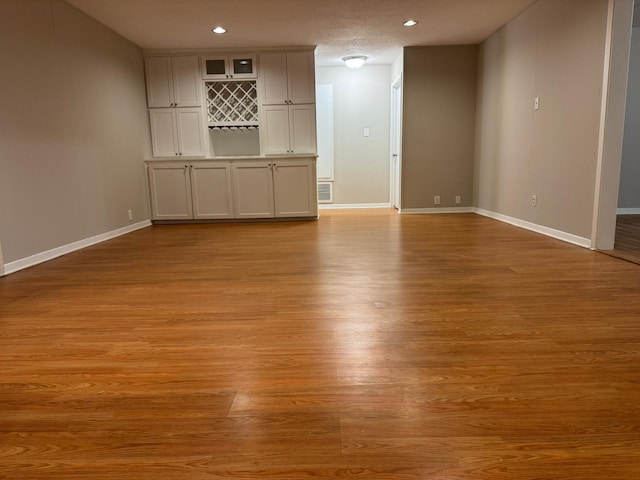 unfurnished living room featuring light wood-type flooring and a textured ceiling