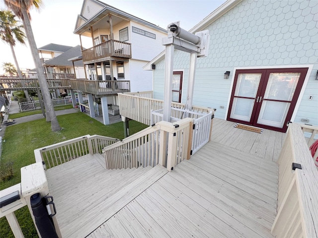 wooden deck with a yard and french doors