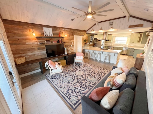 living room with lofted ceiling with beams, wood walls, and ceiling fan