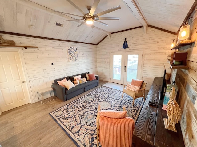 living room featuring french doors, ceiling fan, wooden walls, lofted ceiling with beams, and light hardwood / wood-style floors