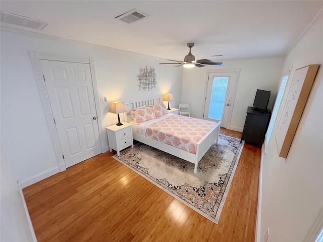 bedroom featuring ceiling fan, hardwood / wood-style floors, and ornamental molding