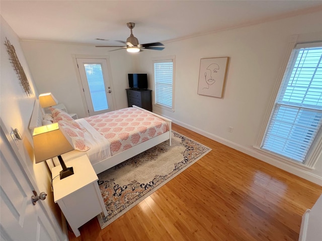 bedroom with hardwood / wood-style floors, ceiling fan, and ornamental molding