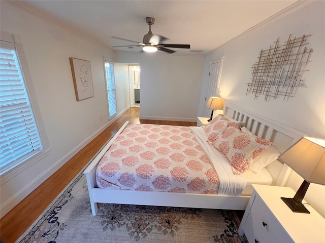 bedroom featuring ceiling fan, crown molding, and wood-type flooring