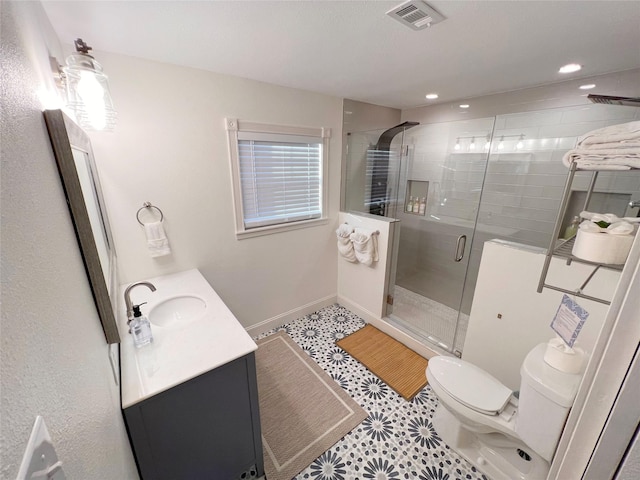 bathroom featuring tile patterned floors, vanity, an enclosed shower, and toilet