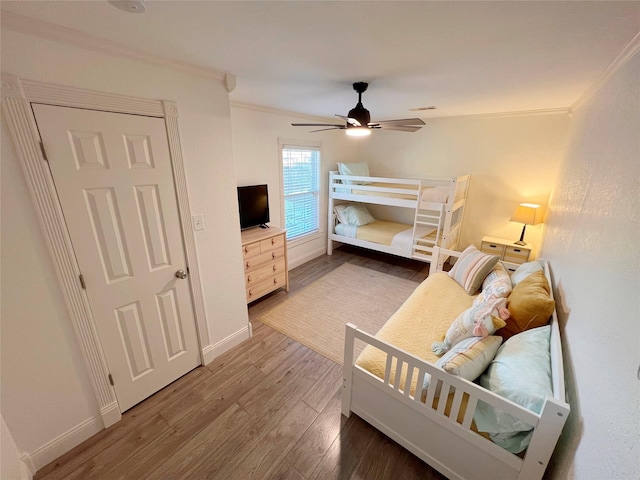 bedroom featuring hardwood / wood-style floors, ceiling fan, and crown molding