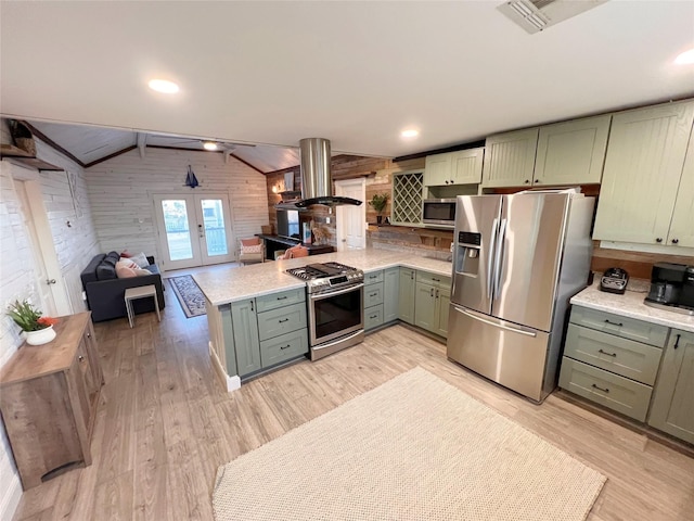 kitchen featuring wooden walls, island exhaust hood, appliances with stainless steel finishes, and green cabinetry