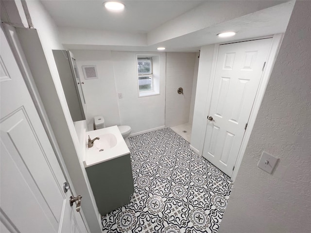 bathroom featuring vanity, toilet, and walk in shower