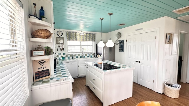 kitchen featuring sink, a center island, white dishwasher, black electric stovetop, and white cabinets