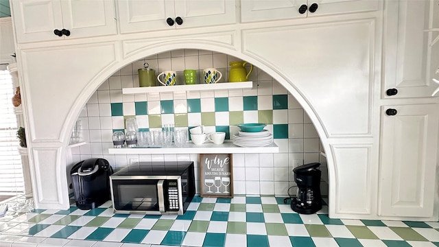 bar featuring tasteful backsplash and white cabinetry