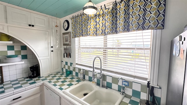 kitchen with tile countertops, dishwasher, sink, and white cabinets