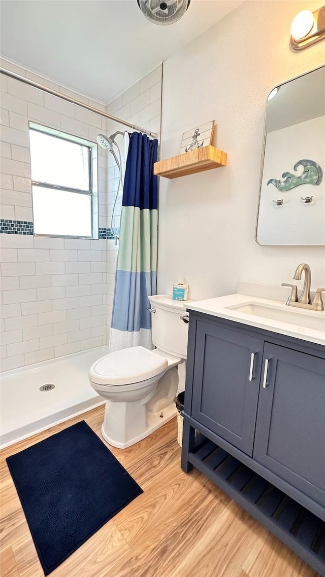 bathroom featuring a shower with shower curtain, wood-type flooring, vanity, and toilet