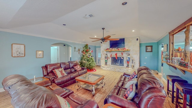 living room with light wood-type flooring, ornamental molding, and vaulted ceiling