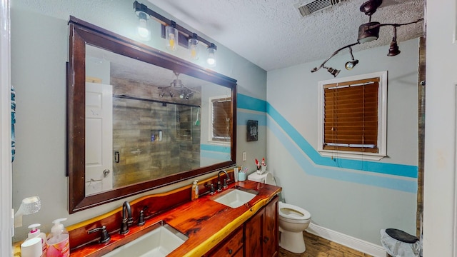 bathroom featuring vanity, hardwood / wood-style flooring, toilet, a textured ceiling, and an enclosed shower