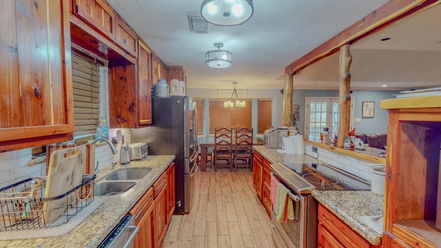 kitchen with decorative backsplash, sink, light hardwood / wood-style floors, and appliances with stainless steel finishes