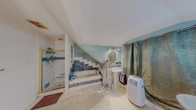 bathroom with a textured ceiling, lofted ceiling, and shower with separate bathtub