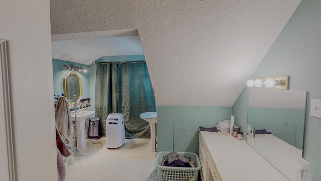 bathroom with a textured ceiling and vaulted ceiling