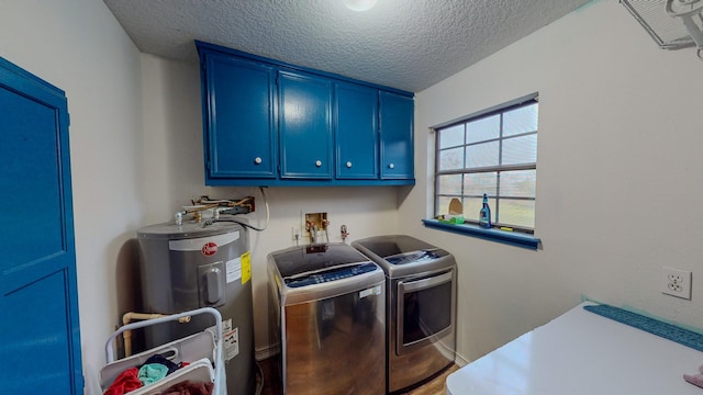 clothes washing area featuring cabinets, a textured ceiling, electric water heater, and washer and dryer