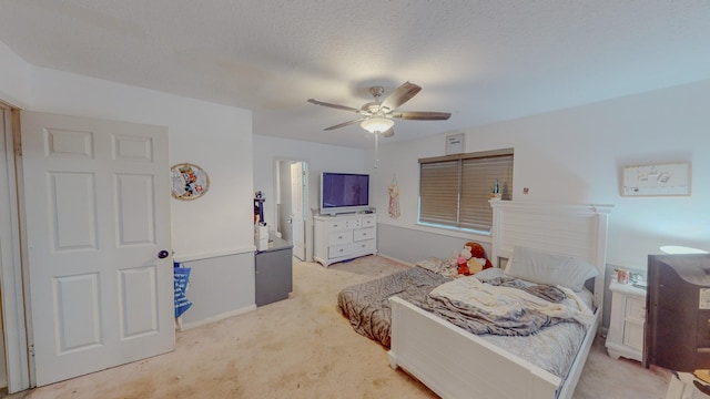 bedroom featuring light carpet, a textured ceiling, and ceiling fan