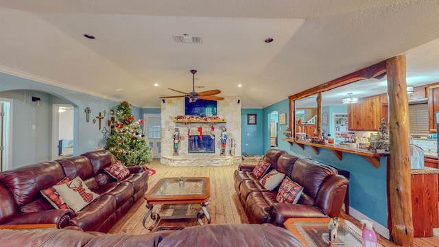 living room featuring ceiling fan, light wood-type flooring, lofted ceiling, and crown molding