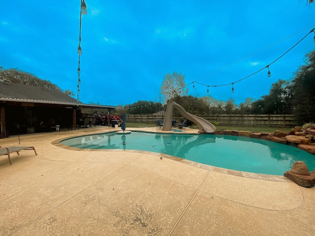 view of swimming pool with a patio and a water slide