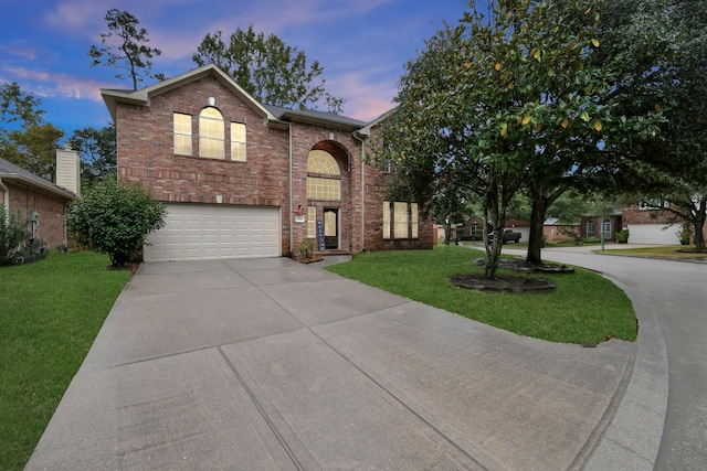 view of front of home with a yard and a garage