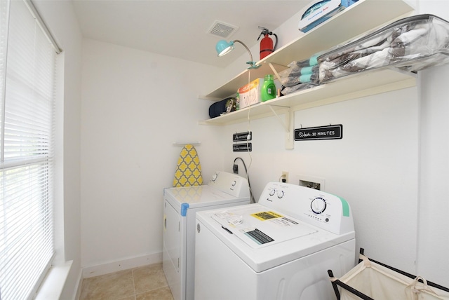 clothes washing area featuring separate washer and dryer and light tile patterned flooring