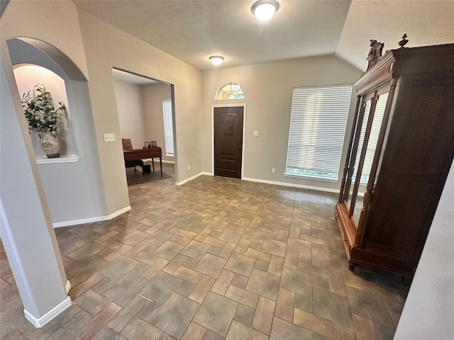 entryway with plenty of natural light and vaulted ceiling