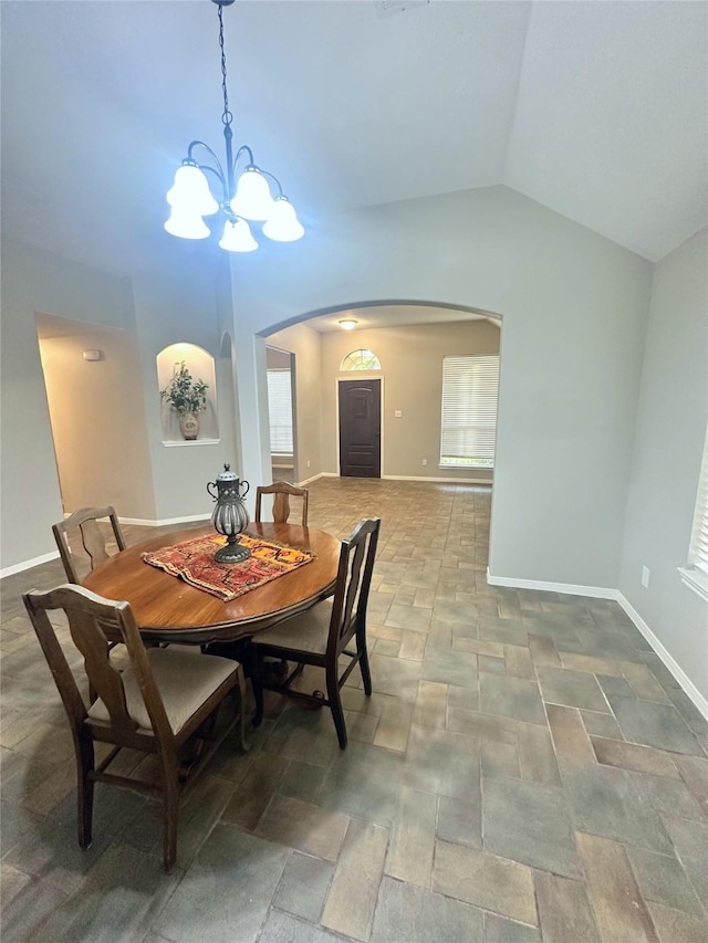 dining area featuring a chandelier and vaulted ceiling