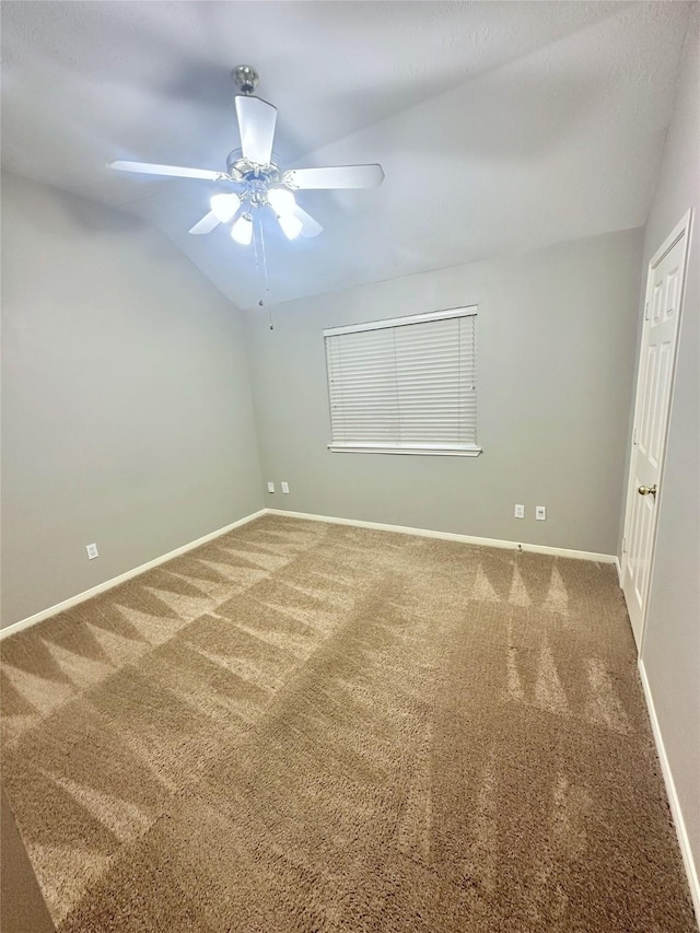 carpeted empty room featuring ceiling fan and lofted ceiling