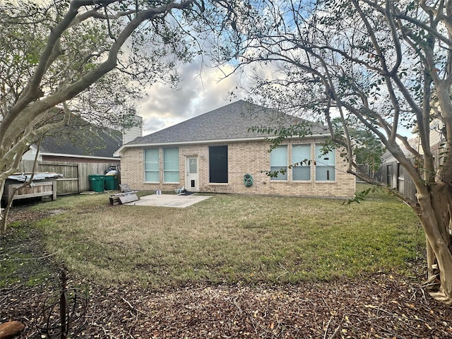 back of house featuring a lawn and a patio area