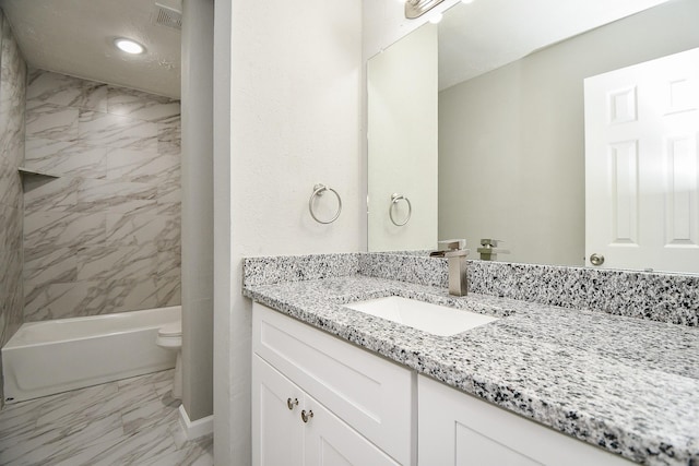 full bathroom with vanity, tiled shower / bath combo, and toilet