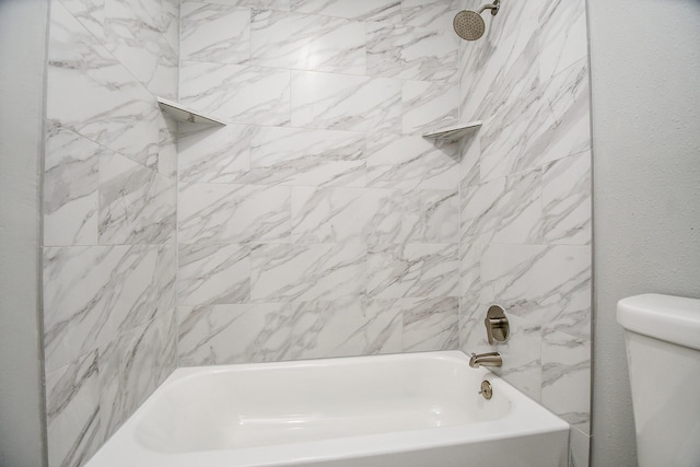 bathroom with toilet and tiled shower / bath