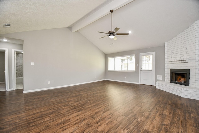 unfurnished living room featuring dark hardwood / wood-style flooring, a brick fireplace, a textured ceiling, ceiling fan, and vaulted ceiling with beams