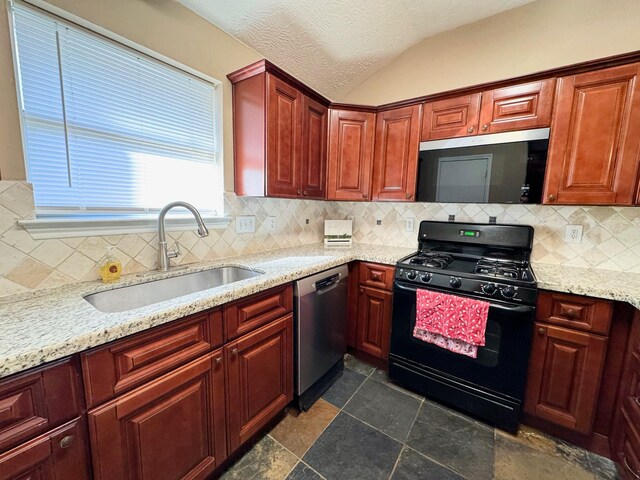 kitchen with lofted ceiling, sink, a textured ceiling, tasteful backsplash, and stainless steel appliances