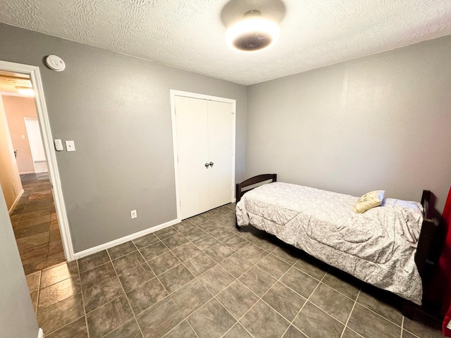 bedroom featuring a textured ceiling and a closet