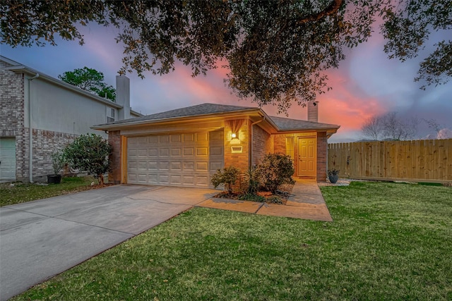 ranch-style home featuring a garage and a lawn