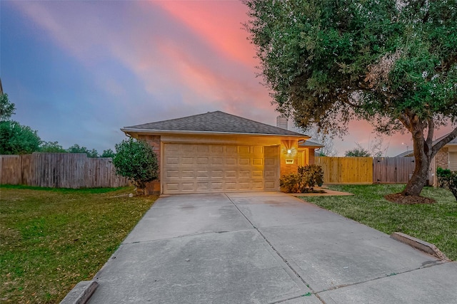 view of front of property with a garage and a yard