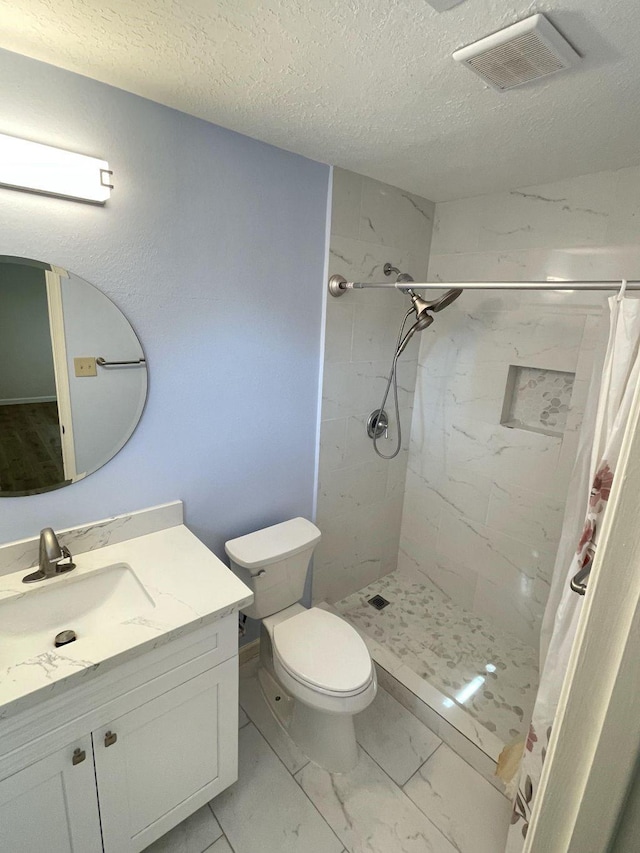 bathroom with vanity, a textured ceiling, toilet, and walk in shower