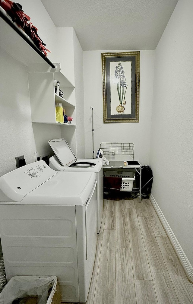 laundry room featuring washer and dryer and light hardwood / wood-style floors