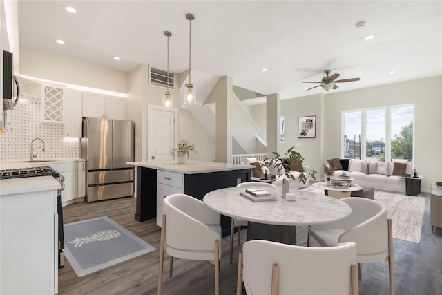 dining room with ceiling fan, wood-type flooring, and sink