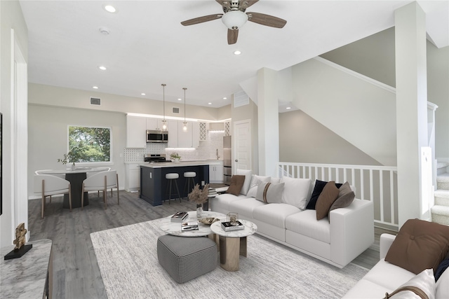 living room with ceiling fan, light hardwood / wood-style flooring, and lofted ceiling