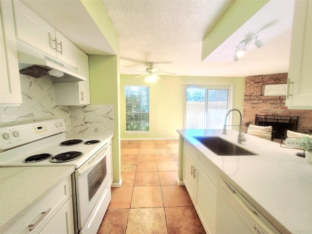 kitchen featuring white appliances, white cabinets, tasteful backsplash, sink, and light tile patterned floors