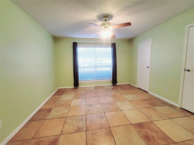 tiled spare room featuring ceiling fan and a textured ceiling