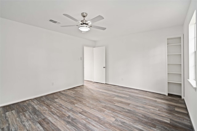 empty room with ceiling fan and dark hardwood / wood-style flooring