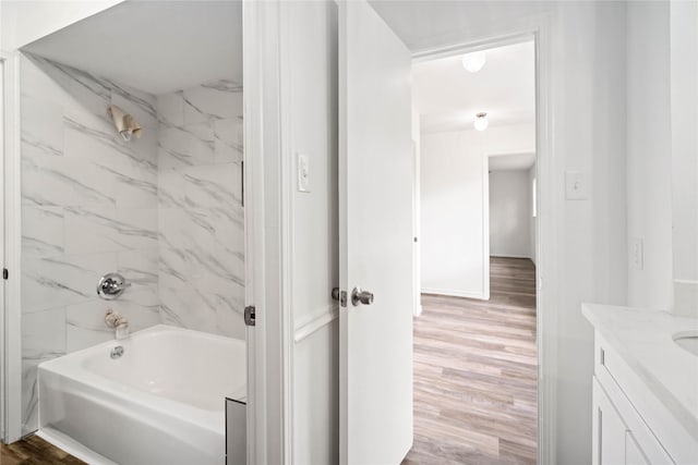 bathroom featuring vanity, wood-type flooring, and tiled shower / bath