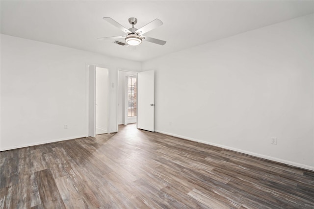 unfurnished room with ceiling fan and dark wood-type flooring